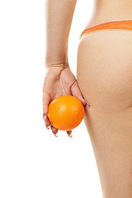 Die hälfte eines Pos und die Hand hängt daneben mit einer Orange in der Hand Die hälfte eines Pos und die Hand hängt daneben mit einer Orange in der Hand