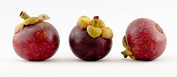 Drei Mangostan Früchte nebeneinander auf weißem Hintergrund Drei Mangostan Früchte nebeneinander auf weißem Hintergrund