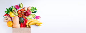 Eine Papiertüte, aus der verschiedenes Obst und Gemüse herausfällt